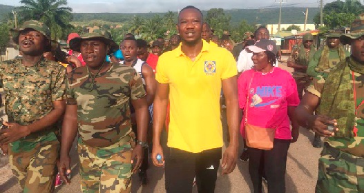 Christopher Apawu (middle) leading management and staff to climb the Asinesi Mountain to end the breast cancer awareness month. They were joined by some soldiers on the walk.